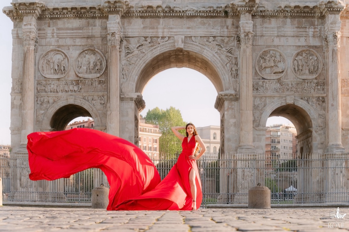 Flying dress pose The Diva: an editorial stance with the red train crossing the frame, Arch of Constantine, Rome
