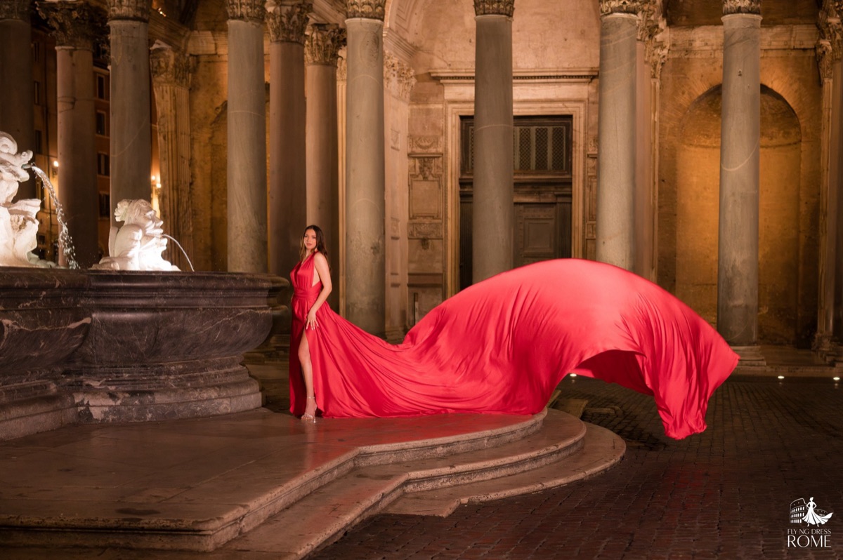 Flying dress pose The Stillness: standing still beside the fountain while the red train opens out into the dark, Pantheon lit at night, Rome